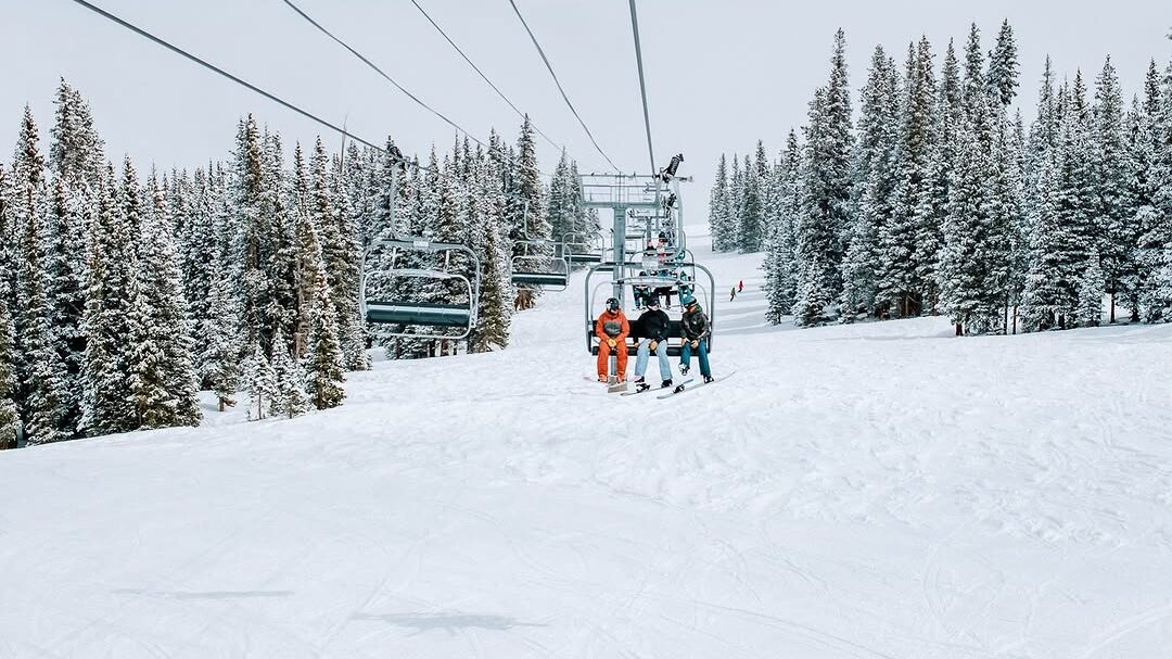 Group of Skiers going up Big Burn Ski Lift during winter in Snowmass, CO.